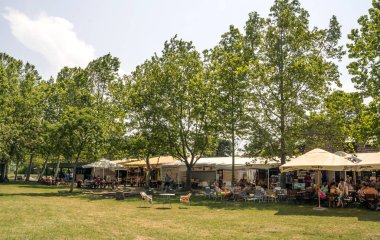 Balatonlelle, Macaristan-Haziran 2019. Güneşli bir günde şehrin gölü yakınında bir yaz günü çim turist.