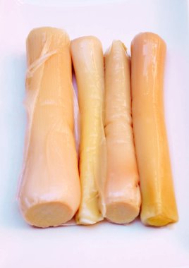 Ahşap masa tarafından çevrili beyaz bir plaka üzerinde dört kereviz 