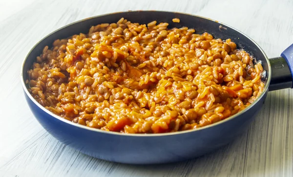 Lentils and rice in a pan surrounded by white background