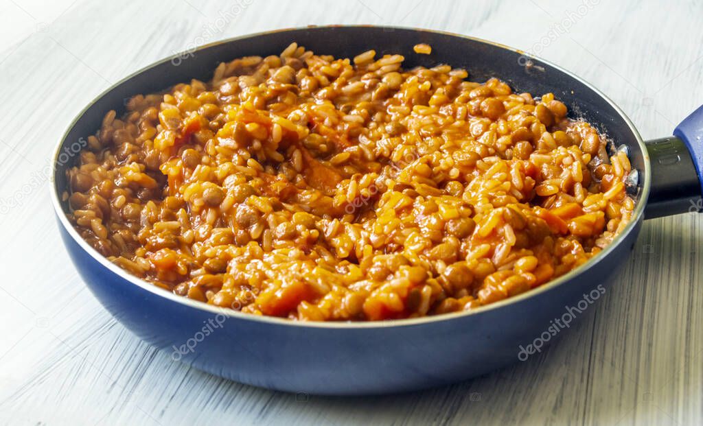 Lentils and rice in a pan surrounded by white background