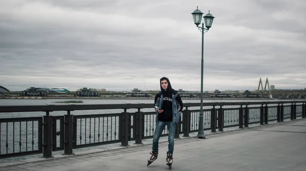 Genç adam paten şehir dolgu üzerinde