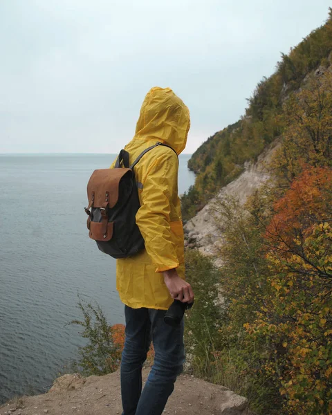 Bir genç yolcusu adam sarı yağmurluk içinde mavi bir taş buldum