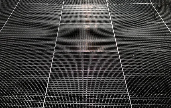 Rejilla de metal en el suelo que refleja sol de la mañana —  Fotos de Stock