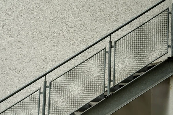 steps with metal stair string at plastered facade