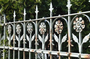 yaprak şeklinde sivri ve çiçek süsleri ile paslı eski çit