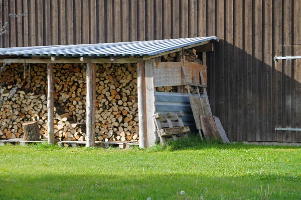 Стопка дров с крышей из листового металла — стоковое фото