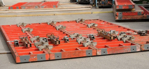 Elementos de cofragem de metal pintado vermelho no local de construção — Fotografia de Stock