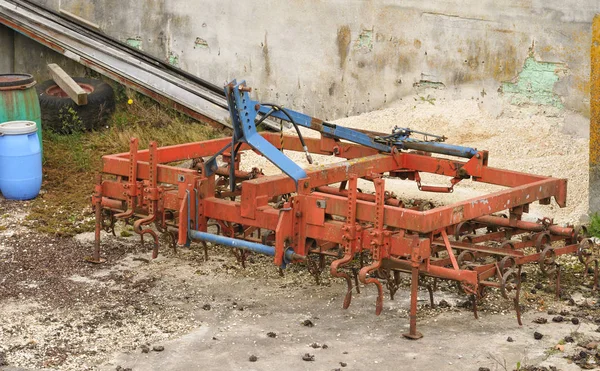 Grade pintada de vermelho deitado no chão em uma fazenda — Fotografia de Stock