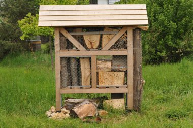 bir çayır üzerinde ahşap çatı ile büyük böcek otel