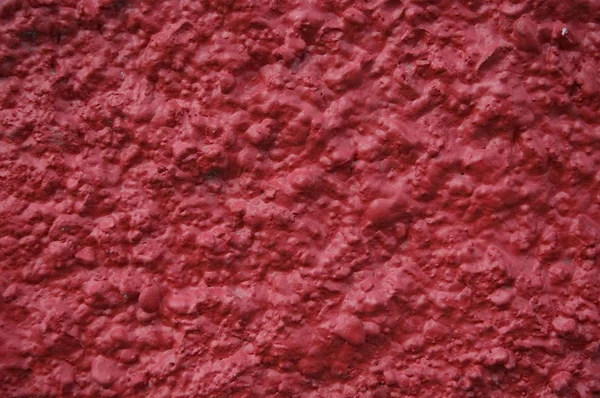 Nahaufnahme der rot gestrichenen Fassade mit rauem Putz — Stockfoto