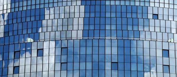 雲と青い空を反射するガラスのファサード — ストック写真