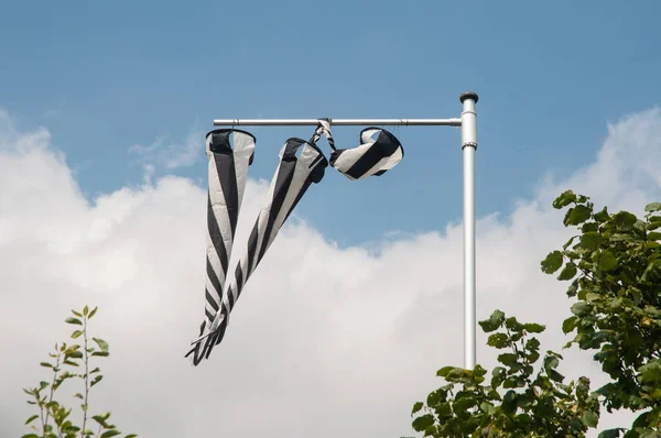 black and white striped wind socks at a flag pole