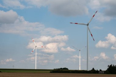 Bulutlu gökyüzü kırsal alanda güç üretimi için dönen rüzgar değirmenleri