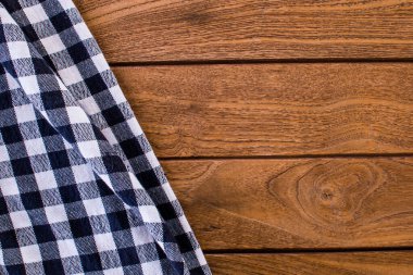 Masa örtüsü, ahşap arka planda damalı pamuk deseni. Kopyalama alanı olan üst görünüm.