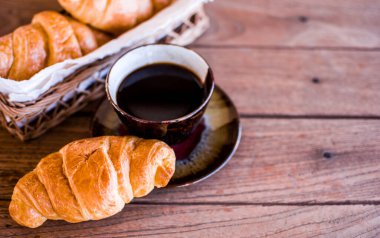 Ahşap arka planda taze kruvasan. Kahvaltı için uygun bir Fransız pastası türüdür. Dünya çapında bir pastaneden alınabilir..