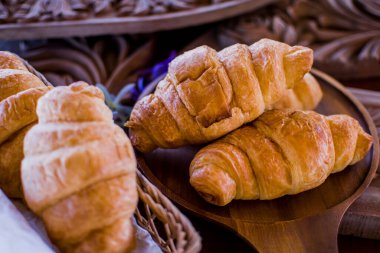 Ahşap arka planda taze kruvasan. Kahvaltı için uygun bir Fransız pastası türüdür. Dünya çapında bir pastaneden alınabilir..
