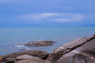 Sahilin deniz manzarası ve doğal taş plajı. Güney Tayland 'ın yağışlı mevsiminde öğle vakti meşhur yer..