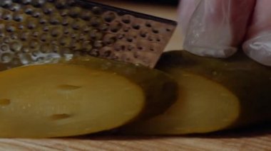 Hamburger yapma Şef. Dilimlenmiş salatalık turşusu ile bıçak yakın çekim yakışıklı adamın