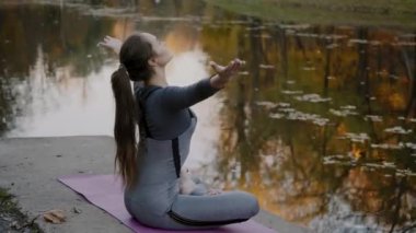 Genç kadın pratik yoga açık havada. Kadın meditasyon açık güzel sonbahar doğa infront.