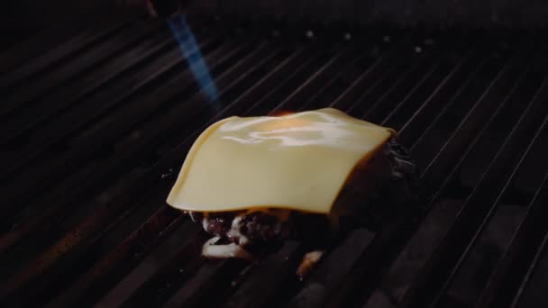 Chef-kok Hamburger maken. Cook smelt kaas op een hamburger. Cook maakt gebruik van een klap fakkel te smelten kaas op een vlees kotelet. Man smelt kaas op een hamburger met behulp van een klap fakkel. — Stockvideo