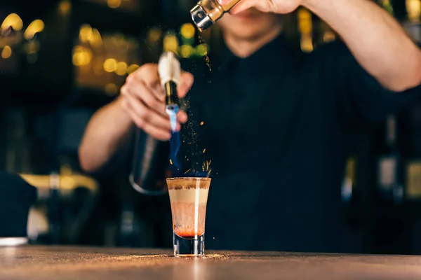 Il barista fa un cocktail di fuoco. Cocktail Hiroshima. Il barista accende l'accendino sul bancone — Foto Stock