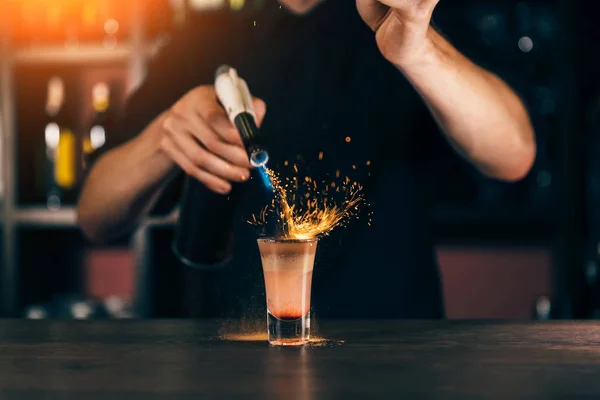 Il barista fa un cocktail di fuoco. Cocktail Hiroshima. Il barista accende l'accendino sul bancone — Foto Stock