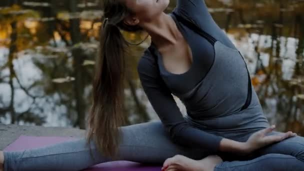 Young woman doing yoga exercises in the autumn city park. Health lifestyle concept. — Stock Video