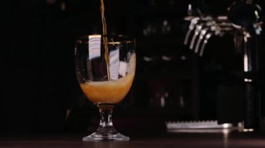 Bir bardak bira dökülen bir barmen atış kapatmak