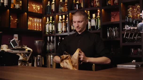 Barman is het reinigen van het glas met een doek op bar teller achtergrond. De barman reiniging van het glas op de balk — Stockvideo