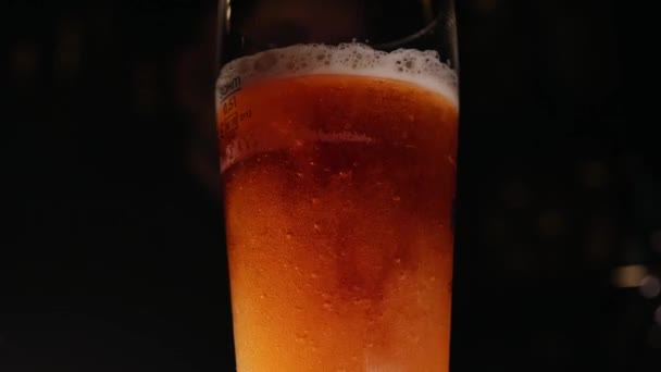 Крупный план бармена, наливающего бокал пива — стоковое видео