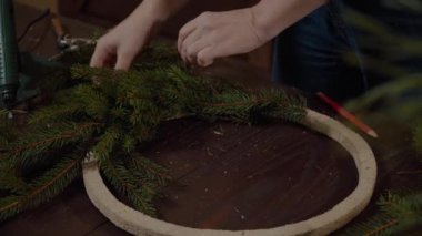 Sevimli genç gülümseyen kadın Tasarımcısı Noel yaprak dökmeyen ağaç çelenk hazırlanıyor. Noel dekor kendi elleriyle üreticisi. Tatil için Noel çelenk. Yeni yıl kutlama. Portre