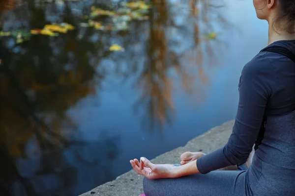Giovane donna che pratica yoga all'aperto. Femmina meditare davanti all'aperto di bella natura autunnale . — Foto Stock