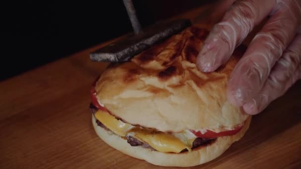 Der Koch legt Burger auf Holzbrett. Koch macht Burger. — Stockvideo