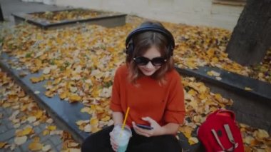 kulaklıklar, kentsel sokak stili, sarı güneş gözlüğü ve dj kulaklık açık sokak stil hipster dj kadında genç kız dinleme müzik dinlemek müzik ve gülümseme, portakal, deli tarzı, sokak çekimi,