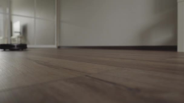 Una aspiradora robótica se desliza a través de la sala de estar moderna. 4K — Vídeos de Stock