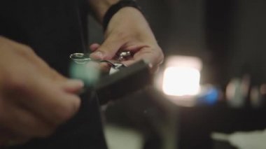 Berber bir sonraki müşteri için makas temizler. Saç kesimi, tıraş için aletlerin bakımı. El yapımı atış. 4k.