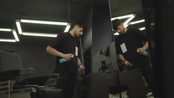 El peluquero desinfecta una tijera con un spray y limpia con un cepillo en una barbería. Un disparo de mano. 4K . — Vídeo de stock