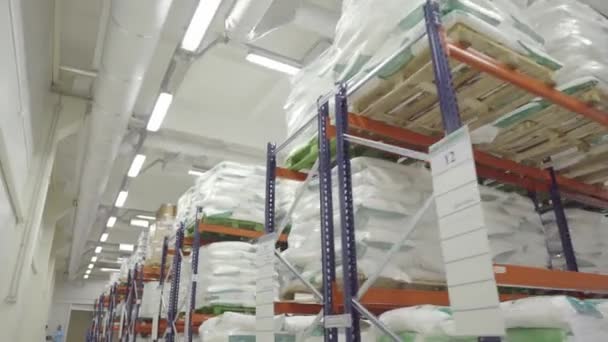 Oversikt over lagerbygninger med kasser og møbler. flytting mellom paletter med varer og materialer på lager . – stockvideo