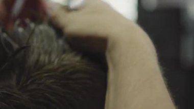 Berber dükkanında saç kesimi sonra saç jölesi ile saç şekillendirme yapar. Genç yakışıklı Beyaz adam modern bir kuaförde saçını kestiriyor. El yapımı atış. 4k.