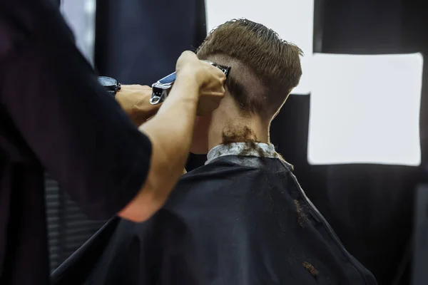 전기 면도칼로 머리를 잘랐어요. 이발사는 미용사를 사용하여 이발소에서 고객을 위해 머리를 깎는다. 전기 샤워기로 머리를 깎고 있는 사람. — 스톡 사진