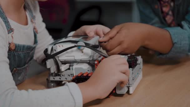 Gemengde rassengroep school kinderen zitten in de klas met DIY robot, stem onderwijsconcept. — Stockvideo