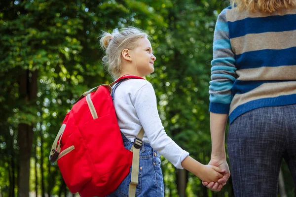 Primeiro dia na escola. Mulher e menina com mochila vermelha nas costas. Início das lições. Primeiro dia de Outono. Voltar ao conceito de escola . — Fotografia de Stock