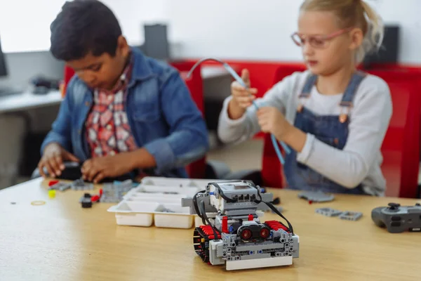 Vegyes faji csoport iskolás gyerekek ül az osztályban a DIY Robot, szár oktatási koncepció. — Stock Fotó