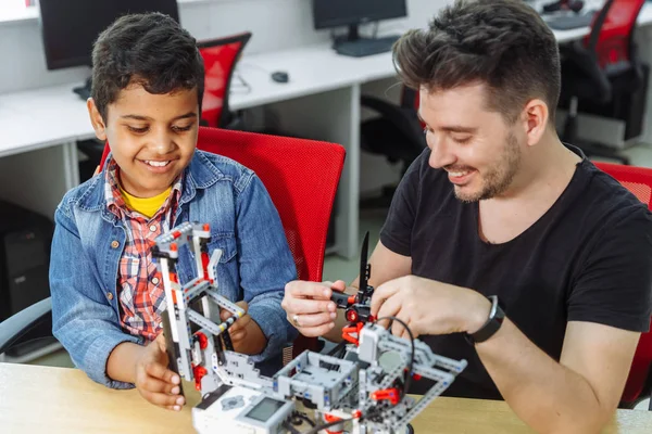 Mixed Racial group of School children controlling robotic machine with remote control together teacher. Creative kids working on the tech project at school. — Stock Photo, Image