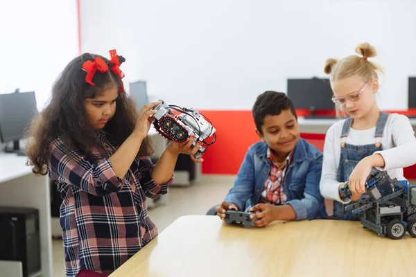 학교에서 기술 프로젝트에 종사하는 크리에이티브 키즈의 혼합 인종 그룹. 학생 소년과 소녀 놀이와 클래스에서 로봇을 제어하는 법을 배웁니다. 스톡 사진