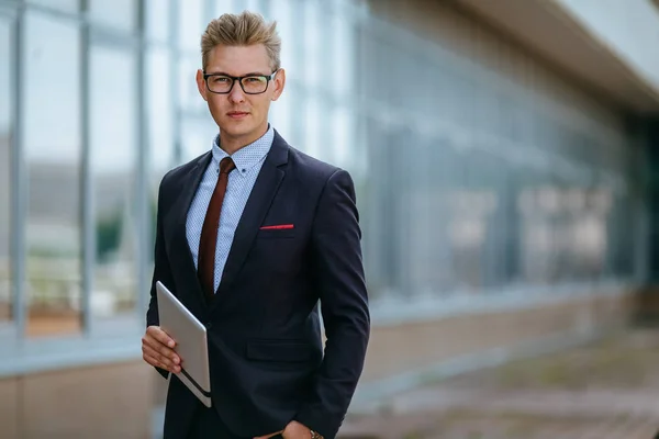 Dijital tablet ile mutlu işadamı. Ofis binasının arka planında elinde tablet Pc ile trendy giysiler içinde bir Erkek yönetici portresi. Modern teknoloji kavramı