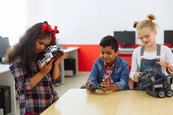 Змішана расова група творчих дітей, що працюють над технічним проектом у школі. Студентський хлопчик і дівчатка грають і вчаться контролювати робота в класі . — стокове фото