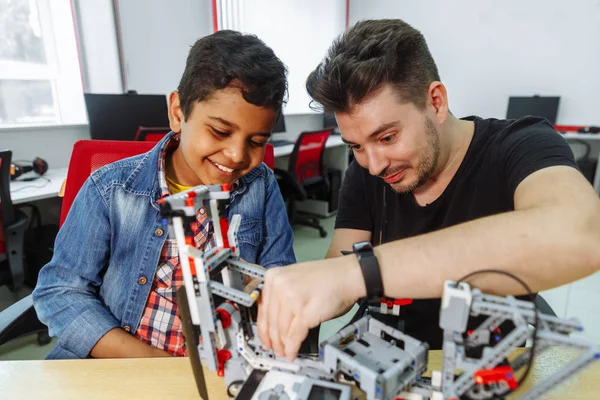 Mixed Racial group of School children controlling robotic machine with remote control together teacher. Creative kids working on the tech project at school. — Stock Photo, Image