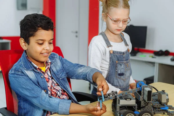 Mieszane rasowe grupy szkolnej dzieci siedzących w klasie z robotem DIY, koncepcja edukacji STEM. — Zdjęcie stockowe