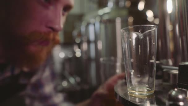 醸造所工場でビールをテストする男性醸造所をクローズアップ。4k. 中小企業のコンセプト. — ストック動画